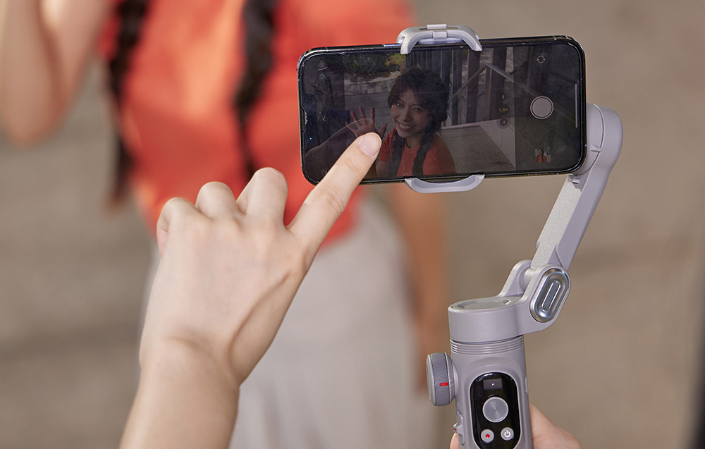 Ένα smartphone σε ένα gimbal καταγράφει μια selfie και ο χρήστης αγγίζει την οθόνη για να ρυθμίσει την εστίαση.