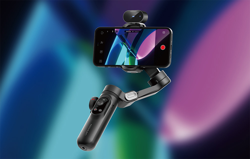 Ένα gimbal με ένα smartphone σε λειτουργία εγγραφής βίντεο, με τη διεπαφή ορατή στην οθόνη, μπροστά από ένα αφηρημένο, πολύχρωμο φόντο.