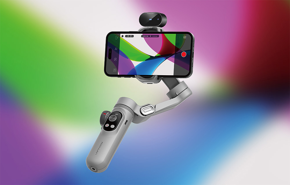 Ένα gimbal με ένα smartphone και μια επιπλέον κάμερα στην κορυφή, παρουσιάζεται μπροστά από ένα φωτεινό, πολύχρωμο φόντο με χρωματική διαβάθμιση.