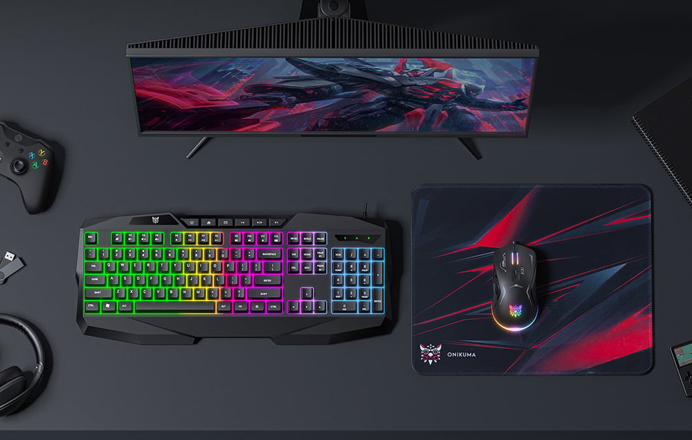 Το πληκτρολόγιο, το ποντίκι και το mouse pad βρίσκονται πάνω σε ένα σκούρο γραφείο δίπλα στην οθόνη