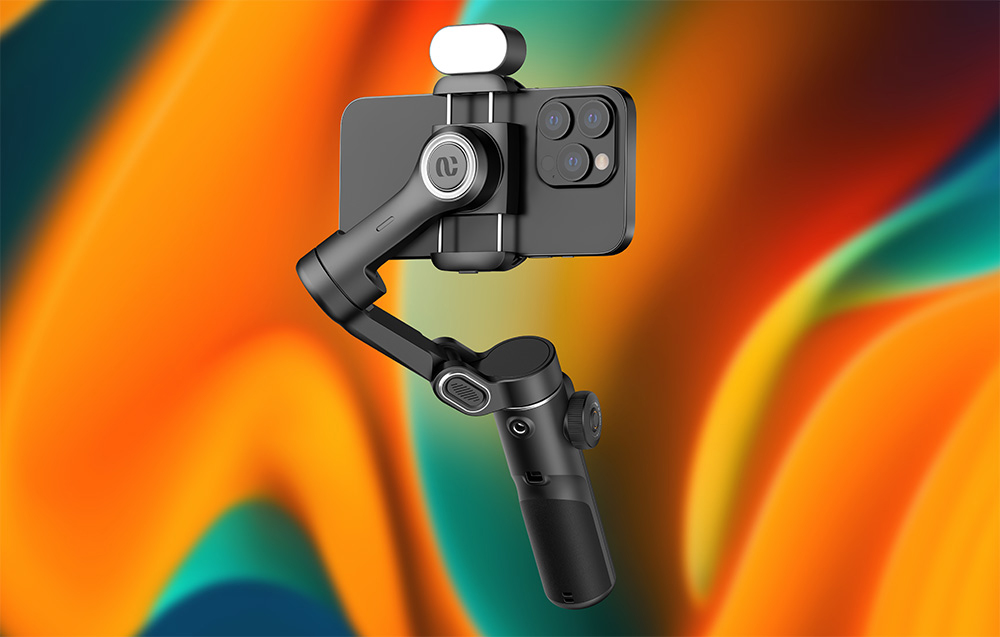 Ένα μαύρο gimbal με ένα smartphone και ένα φως προσαρτημένο στην κορυφή, μπροστά από ένα πολύχρωμο φόντο με ντεγκραντέ.