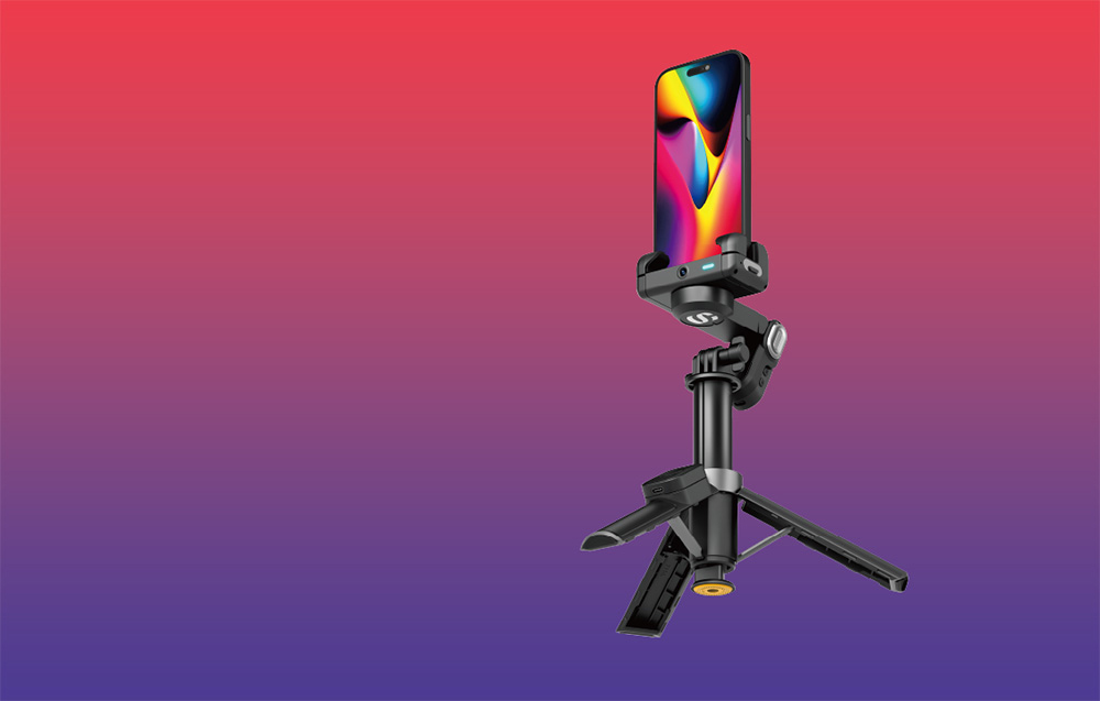 Gimbal με smartphone τοποθετημένο κάθετα σε μίνι τρίποδο πάνω σε φόντο με κόκκινο-μοβ ντεγκραντέ.