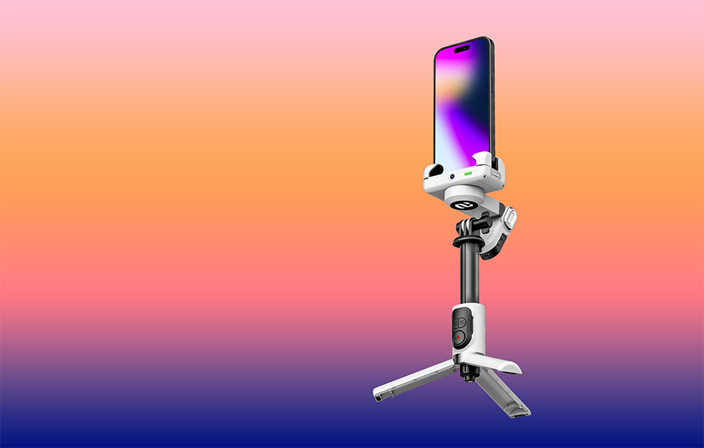 Ένα gimbal με ένα smartphone τοποθετημένο σε ένα μίνι τρίποδο μπροστά από ένα φόντο με χρωματική διαβάθμιση πορτοκαλί-μοβ.