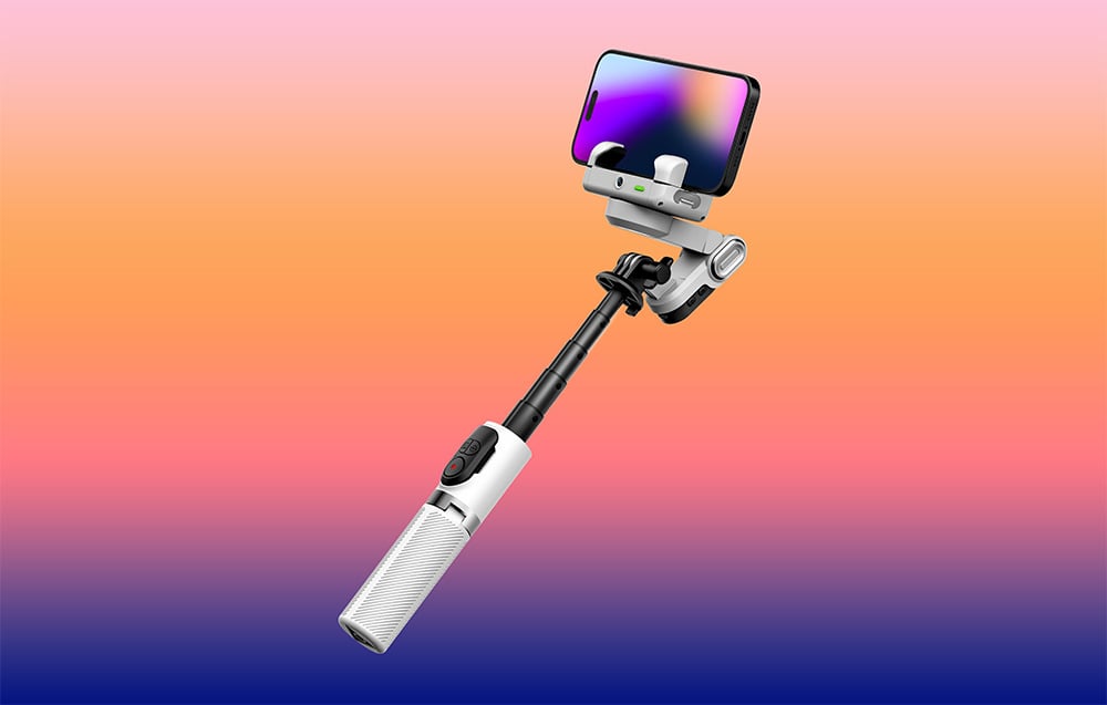 Ένα gimbal με ένα smartphone σε έναν βραχίονα επέκτασης μπροστά από ένα φόντο με ντεγκραντέ σε αποχρώσεις του πορτοκαλί και του μωβ.