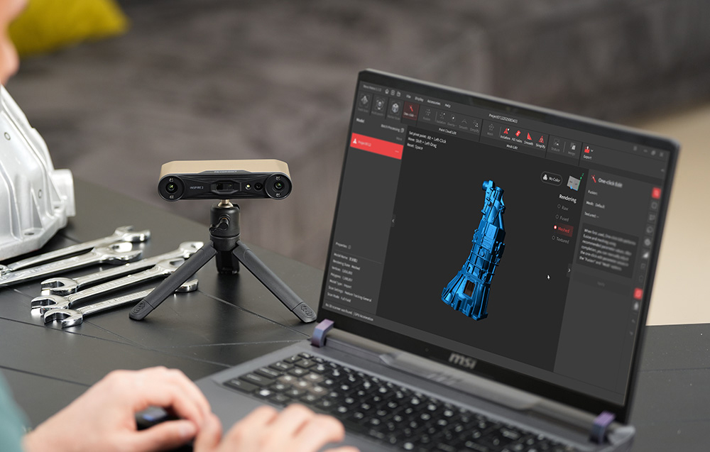 Ένας 3D σαρωτής Revopoint Inspire 2 σε τρίποδο δίπλα σε έναν φορητό υπολογιστή που εκτελεί λογισμικό 3D σε ένα εργαστήριο