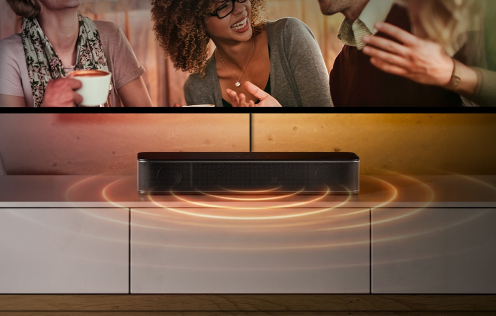 Μια μαύρη soundbar πάνω σε μια λευκή συρταριέρα κάτω από την τηλεόραση