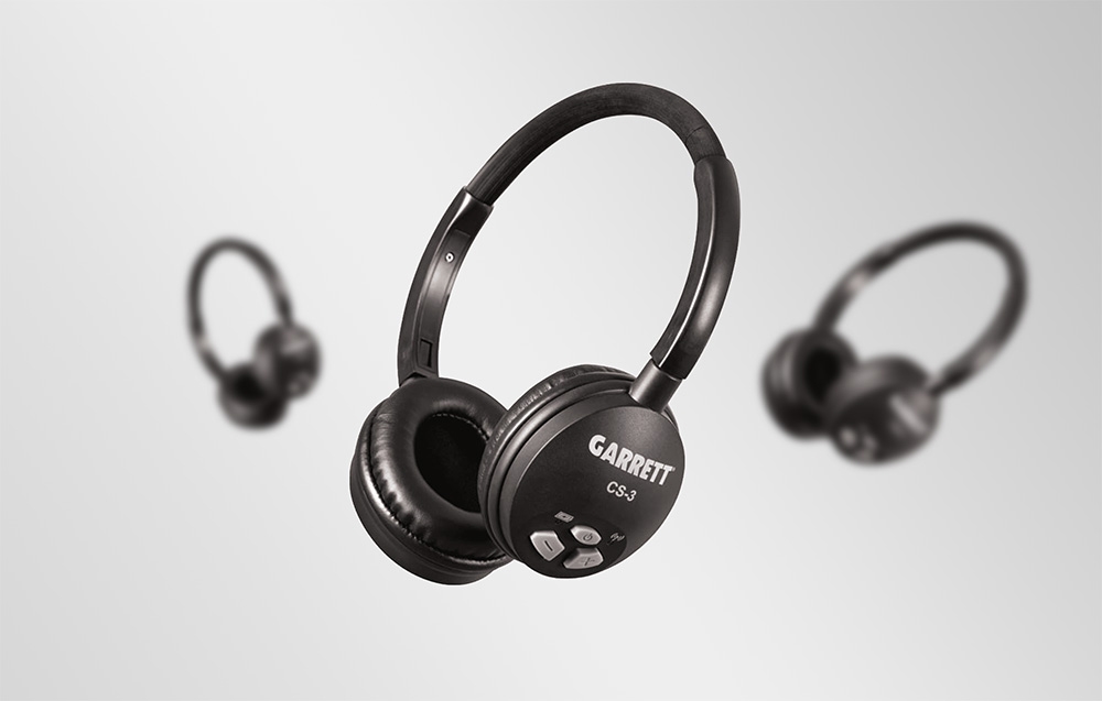 Τρία ζευγάρια ασύρματων ακουστικών Garrett CS-3 διατεταγμένα σε μια δυναμική σύνθεση πάνω σε γκρι φόντο.