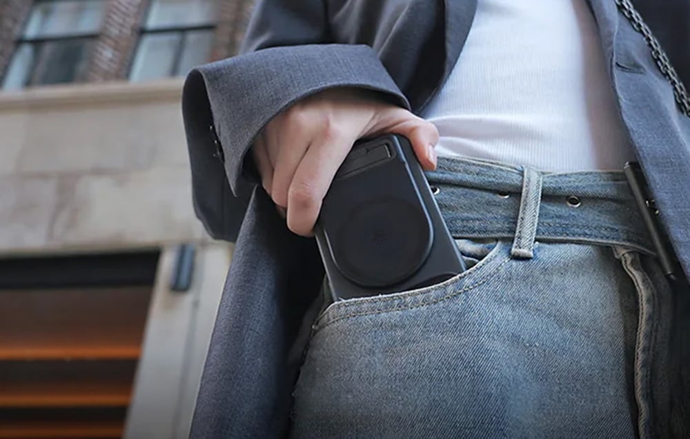 Ένα άτομο που βάζει ένα smartphone με λαβή στην μπροστινή τσέπη του τζιν του
