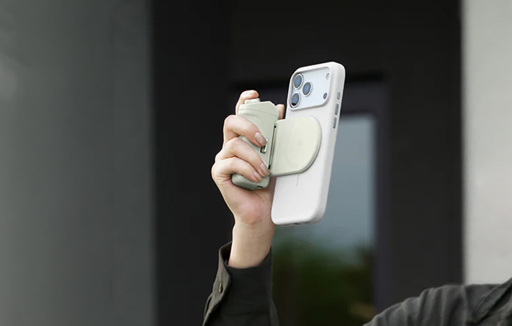 Ένα άτομο κρατά ένα smartphone με τη λαβή προσαρτημένη και τραβάει μια φωτογραφία σε κατακόρυφη λειτουργία