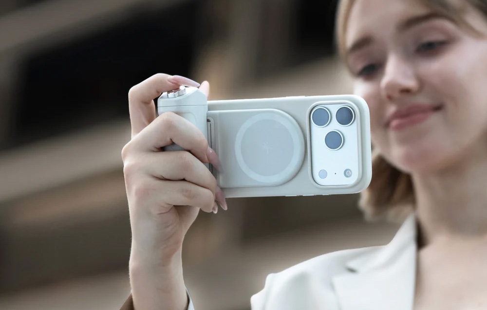 Μια γυναίκα κρατά ένα smartphone με λαβή και τραβάει μια φωτογραφία σε εξωτερικό χώρο