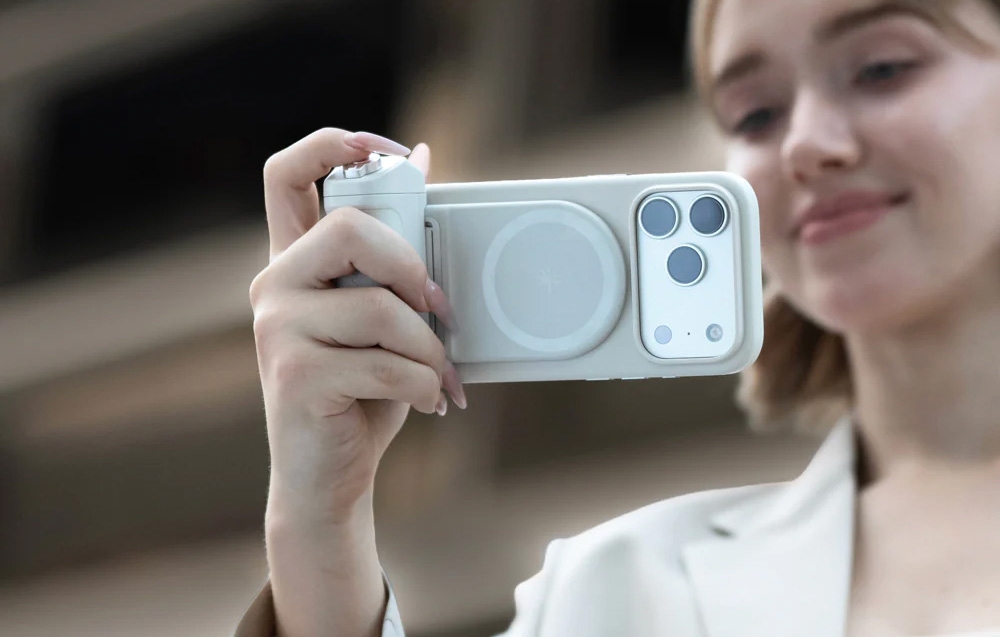 Μια γυναίκα που κρατά ένα smartphone με τη βάση και τραβάει μια φωτογραφία σε εξωτερικό χώρο