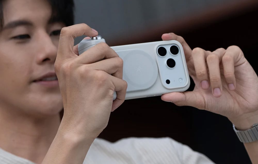Ένα άτομο που κρατά ένα smartphone με λαβή και τραβάει μια φωτογραφία οριζόντια