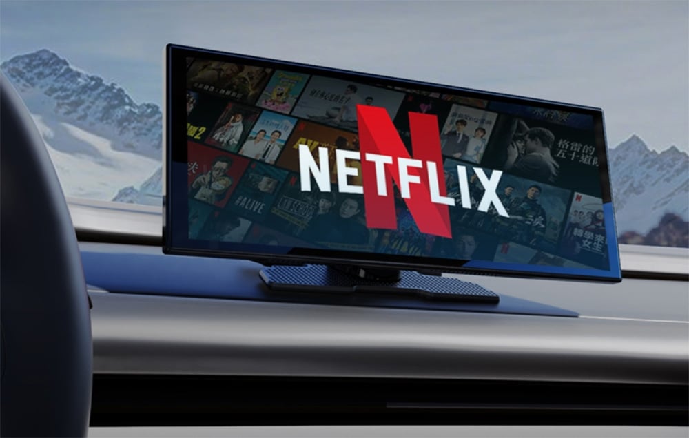Μια οθόνη αυτοκινήτου με το λογότυπο της Netflix με φόντο χιονισμένα βουνά, τοποθετημένη στο ταμπλό