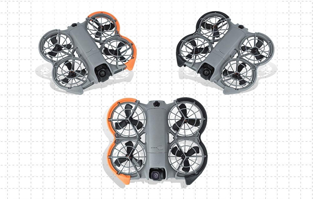 Τρία γκρι drone με προστατευτικά έλικα (πορτοκαλί, μαύρο και μεικτό) τοποθετημένα σε φόντο με ελαφριά πουά