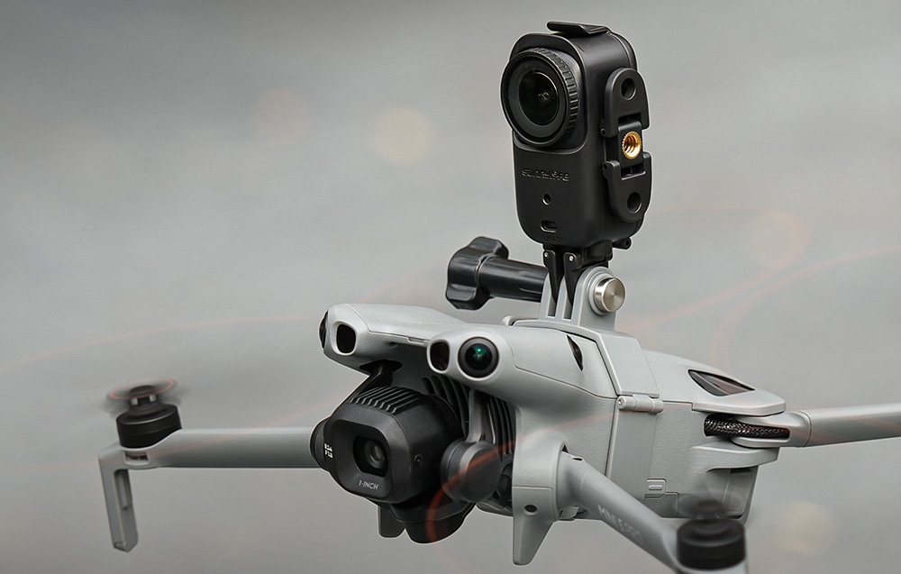 Ένα γκρι drone με μια μαύρη κάμερα δράσης τοποθετημένη κάθετα στην κορυφή, με θολό φόντο
