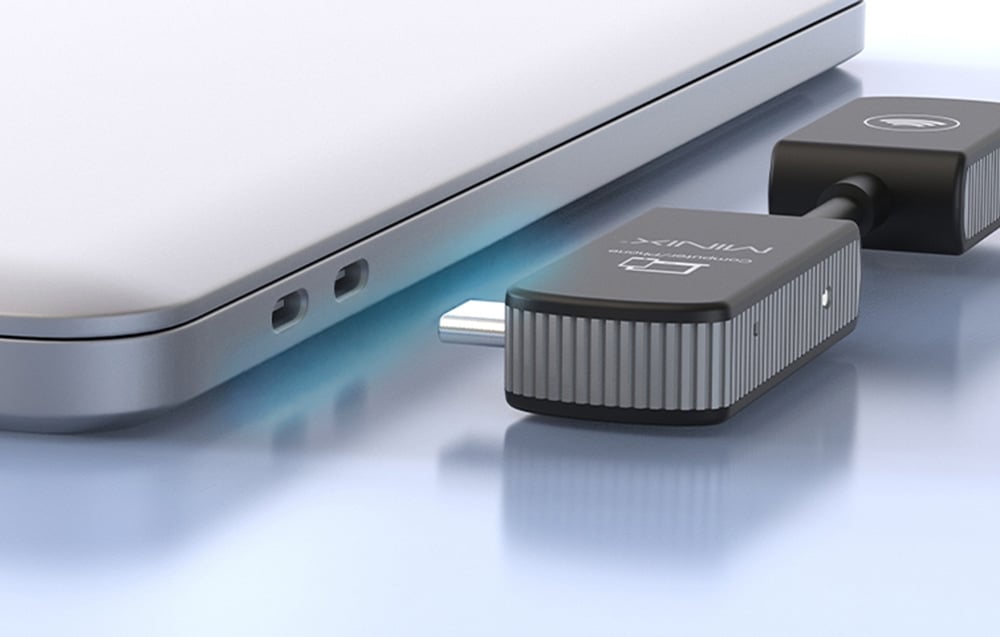 Κοντινό πλάνο της υποδοχής USB-C του προσαρμογέα MINIX Computer/Phone δίπλα στις πλευρικές θύρες του φορητού υπολογιστή