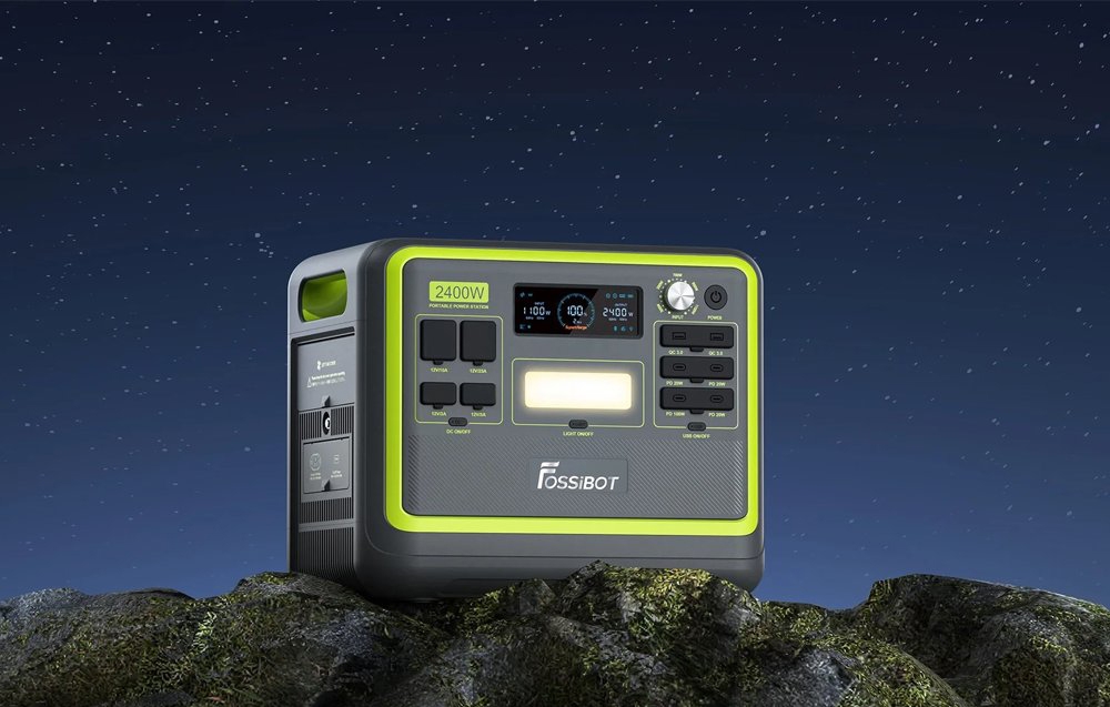 Φορητός σταθμός τροφοδοσίας Fossibot 2400W με φως LED πάνω σε βράχους κάτω από έναν έναστρο ουρανό