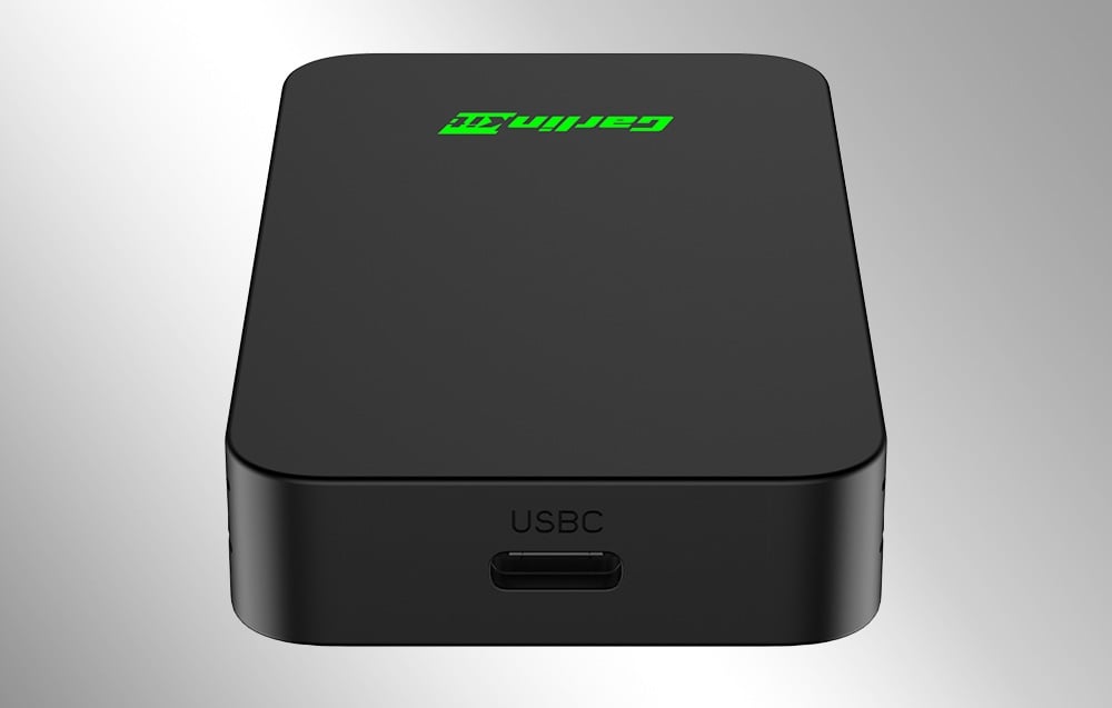 Μαύρος προσαρμογέας CarlinKit με θύρα USB-C, όπως φαίνεται από μπροστά σε ανοιχτόχρωμο φόντο