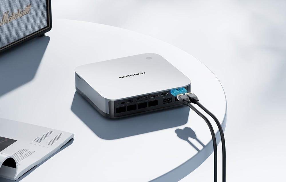 Πίσω πάνελ του λευκού Mini PC με συνδεδεμένα καλώδια δικτύου και ορατές θύρες USB και HDMI.