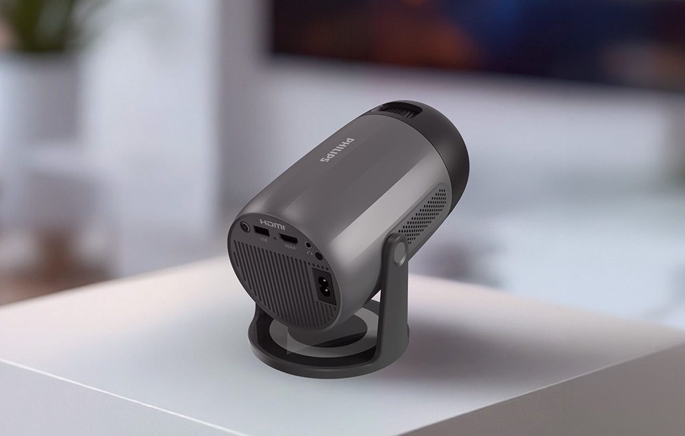 Η πίσω πλευρά ενός μαύρου προβολέα PHILIPS σε λευκό φόντο με ορατές θύρες HDMI και USB