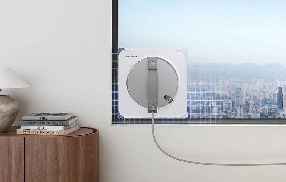 Το ρομπότ ECOVACS καθαρίζει ένα παράθυρο κατά μήκος της άκρης του σε ένα φωτεινό δωμάτιο