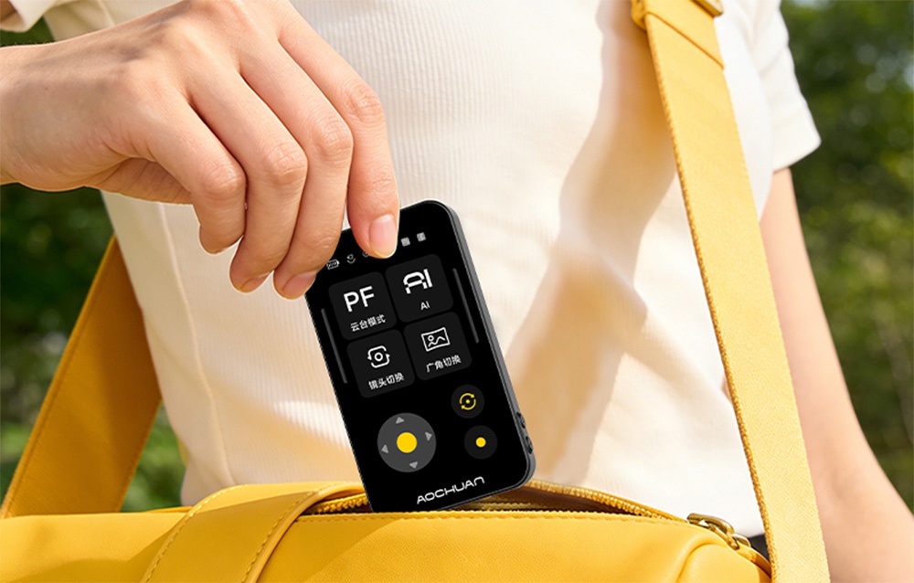 Μαύρη μονάδα με οθόνη LCD για το γυροσκόπιο Aochuan Smart X Pro που βγαίνει από μια κίτρινη τσάντα μέσης