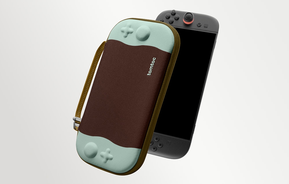 Μια καφέ και μιντ θήκη tomtoc δίπλα σε μια κονσόλα Nintendo Switch σε ανοιχτόχρωμο φόντο.
