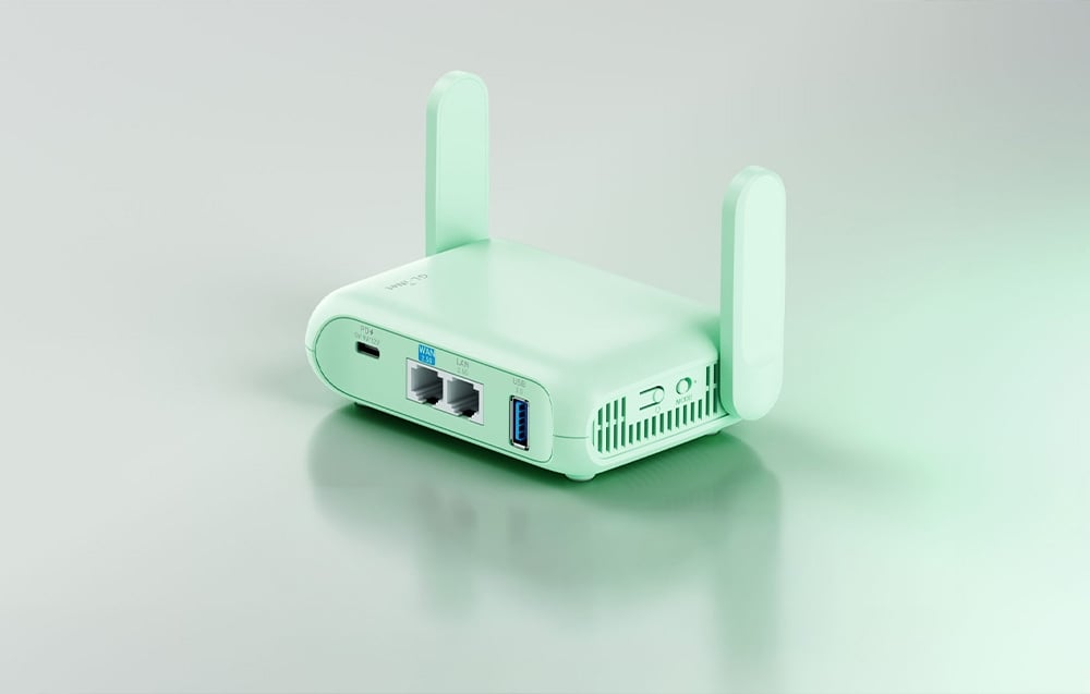 Ένας πράσινος δρομολογητής GL.iNet βρίσκεται πάνω σε ένα ανοιχτόχρωμο τραπέζι