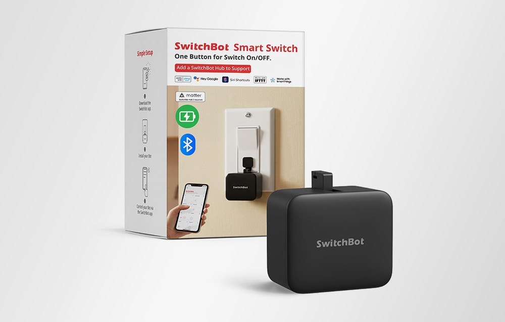Ένας μαύρος έξυπνος διακόπτης SwitchBot δίπλα στη συσκευασία του.