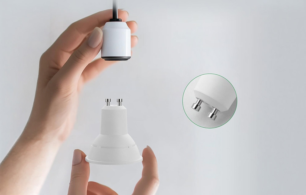 Χέρια που κρατούν έναν λευκό λαμπτήρα και ένα αντίστοιχο αμπαζούρ.