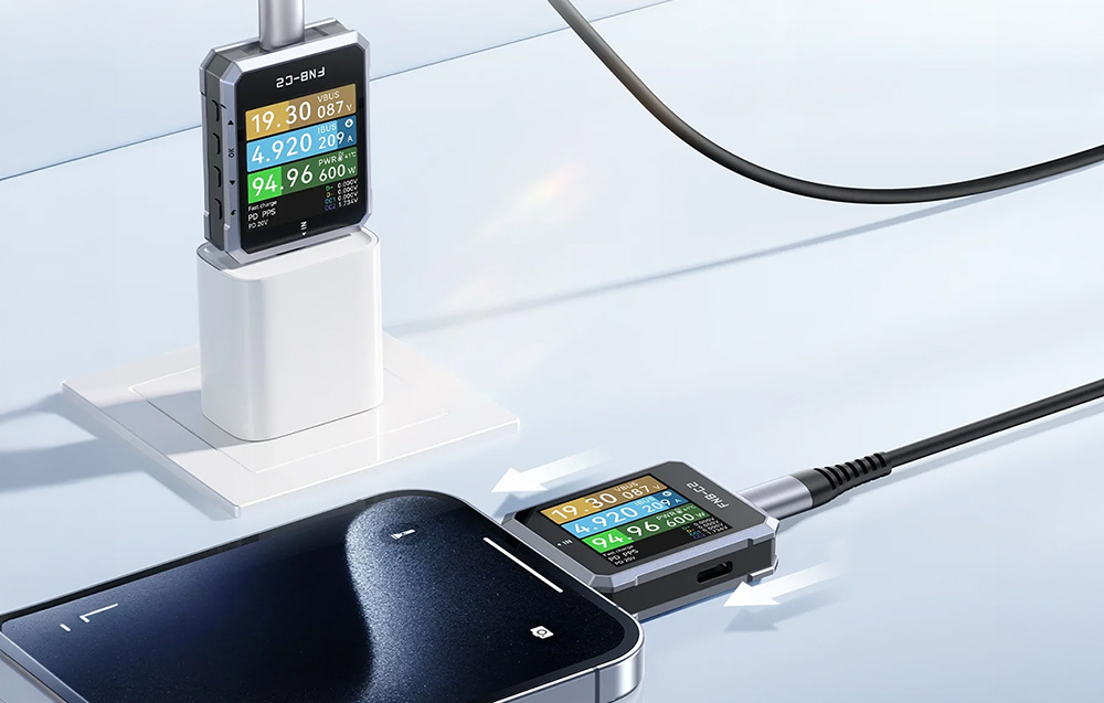 Δύο συσκευές μέτρησης USB που μετρούν παραμέτρους φόρτισης: η μία δίπλα στο φορτιστή που είναι συνδεδεμένος σε πρίζα, η άλλη συνδεδεμένη σε smartphone.