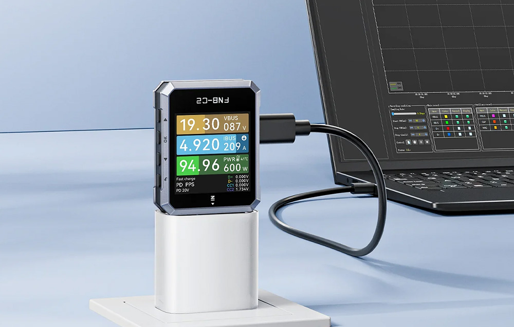 Ένας ελεγκτής USB συνδεδεμένος σε φορτιστή και συνδεδεμένος μέσω μαύρου καλωδίου σε ανοιχτό φορητό υπολογιστή.