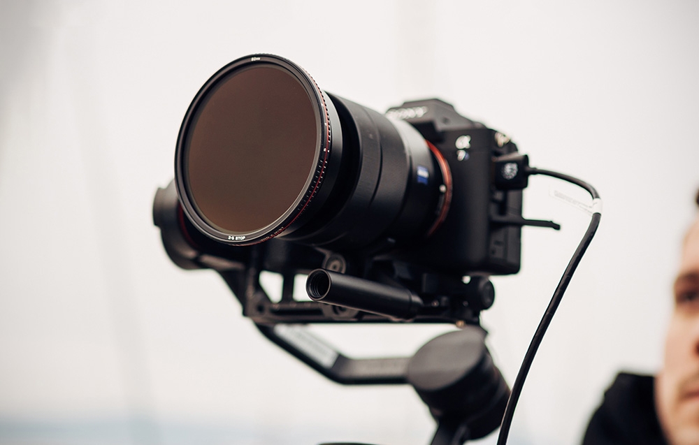 Μαύρη φωτογραφική μηχανή Sony σε σταθεροποιητή (gimbal) με ρυθμιζόμενο κυκλικό φίλτρο ND της Freewell τοποθετημένο στον φακό