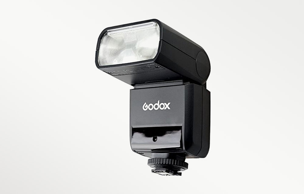 Το φλας Godox TT350 σε όψη από μπροστά υπό γωνία, με την κεφαλή του φλας στραμμένη ελαφρώς προς τα πάνω