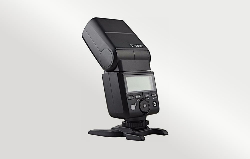 Μαύρο φλας Godox TT350 σε μαύρη βάση, πίσω όψη, με την οθόνη LCD απενεργοποιημένη και την κεφαλή κεκλιμένη προς τα πίσω