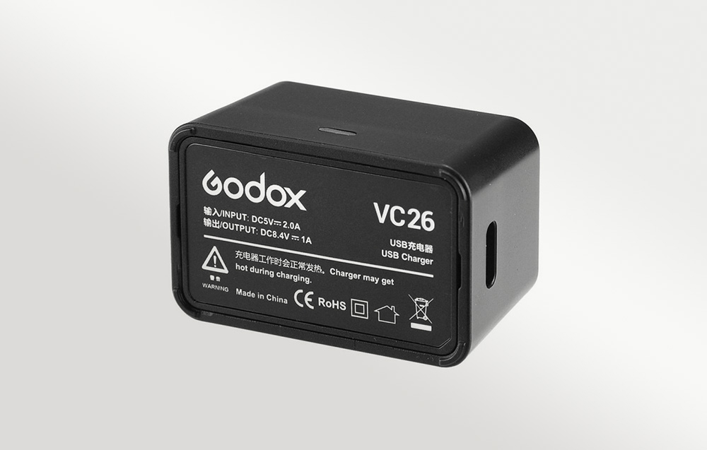 Ο φορτιστής μπαταριών GODOX VC26, όπως φαίνεται από κάτω, με φόντο γκρι ντεγκραντέ