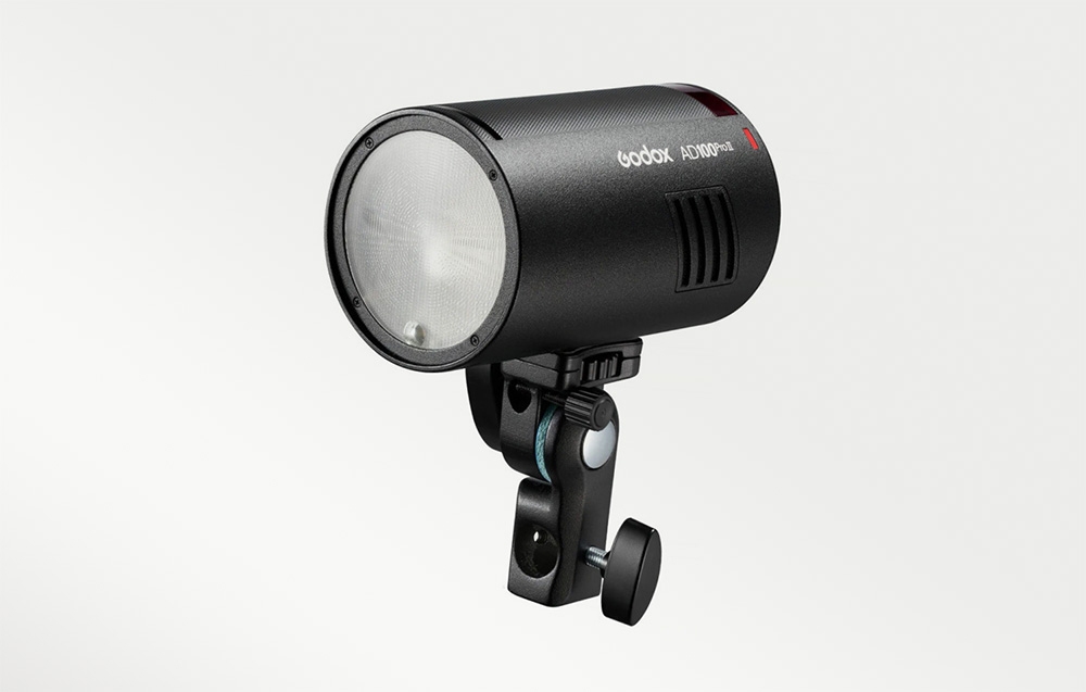 Ένα φλας Godox AD100Pro II τοποθετημένο υπό γωνία σε βάση στήριξης, με την στρογγυλή κεφαλή του φλας ορατή