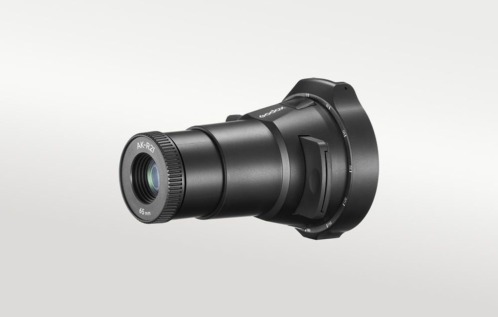Εξάρτημα προβολής Godox AK-R21 με φακό 65 mm, απεικονιζόμενο προφίλ σε ανοιχτό γκρι φόντο