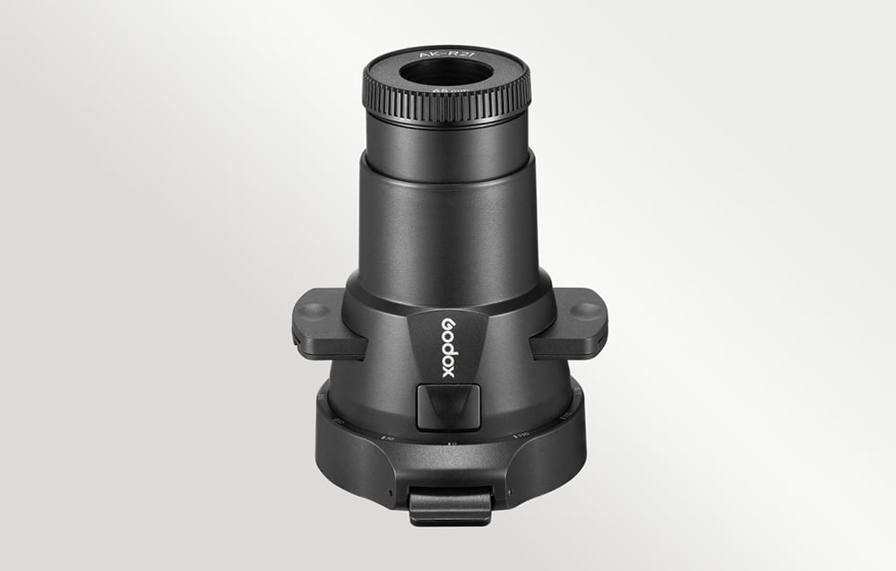 Μαύρο εξάρτημα προβολής Godox AK-R21 τοποθετημένο κάθετα, απεικονιζόμενο από πάνω σε ανοιχτόχρωμο φόντο