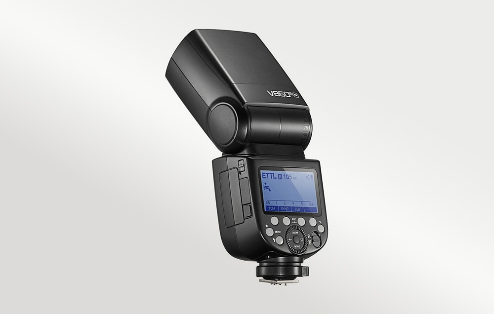 Ο φλας Godox V860III υπό γωνία, όπου φαίνονται ο πίνακας ελέγχου, η οθόνη και η κεκλιμένη κεφαλή