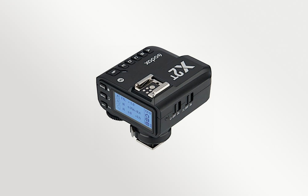Ο μαύρος ραδιοπομπός Godox X2T-N, όπως φαίνεται υπό γωνία με την οθόνη LCD με οπίσθιο φωτισμό