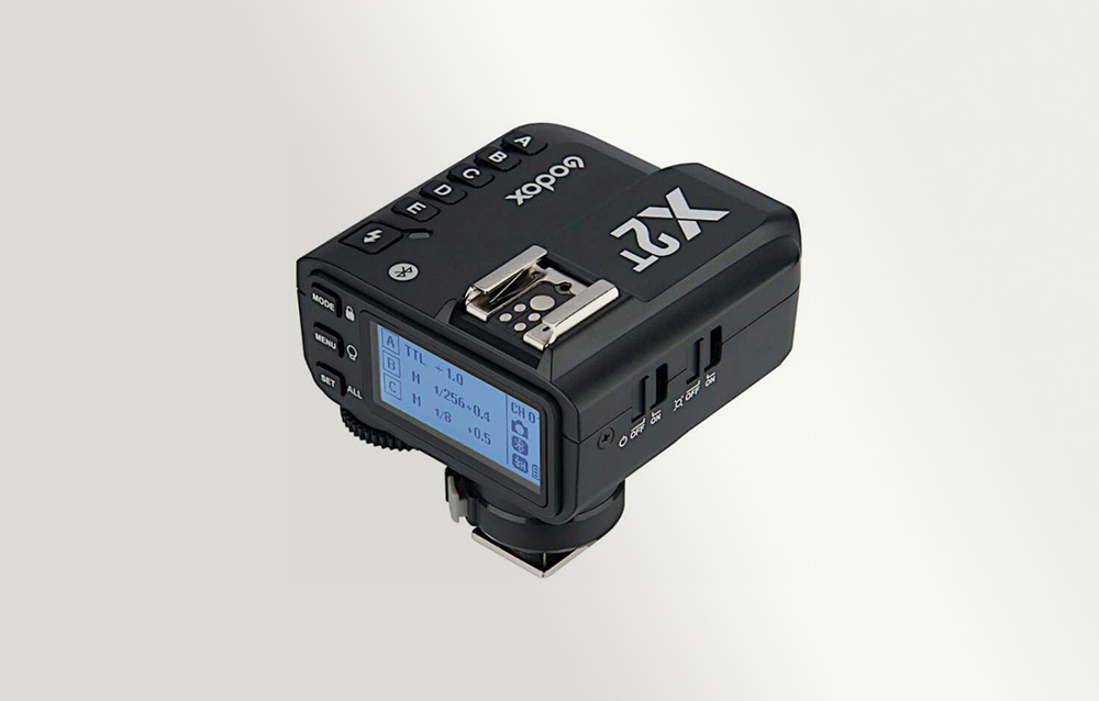 Ο μαύρος ραδιοπομπός Godox X2T, όπως φαίνεται υπό γωνία με την οθόνη LCD με οπίσθιο φωτισμό