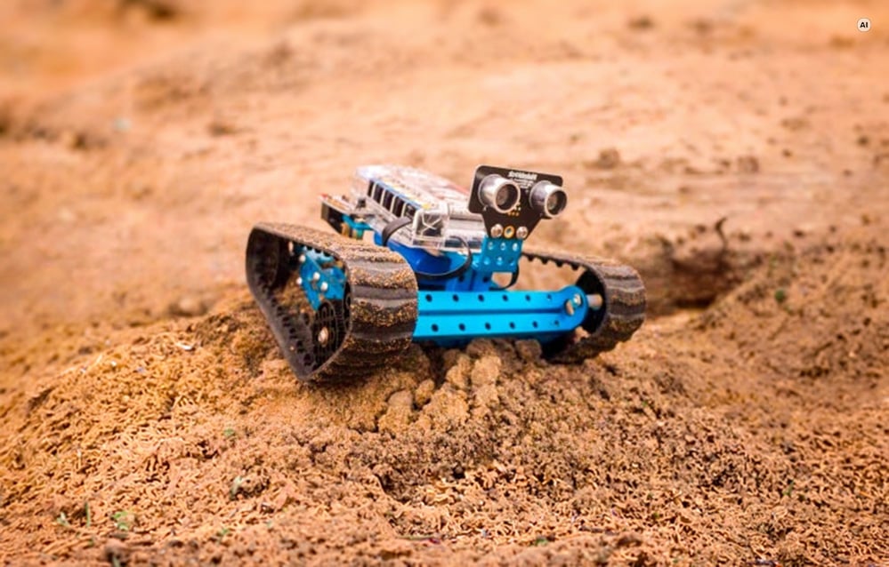 Το εκπαιδευτικό ρομπότ Makeblock mBot Ranger με ερπύστριες κινείται σε αμμώδες έδαφος