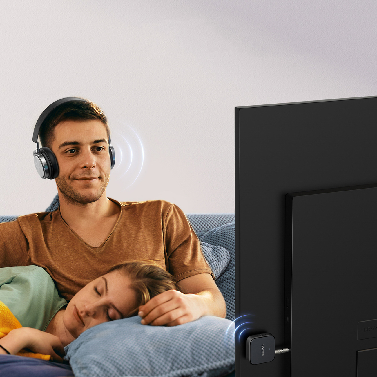 Ένας άντρας παρακολουθεί με ακουστικά χρησιμοποιώντας τον πομπό Ugreen CM667 35223