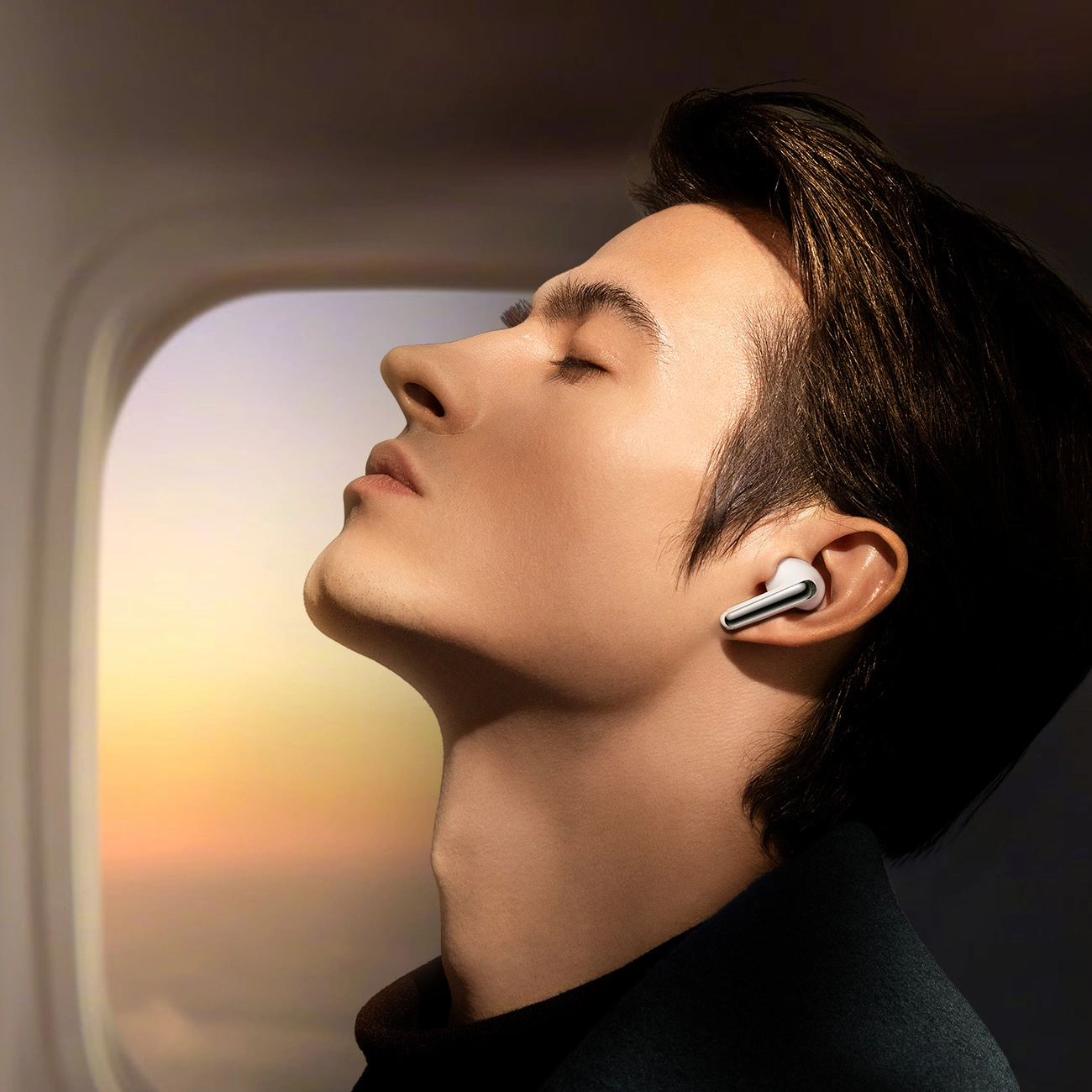 Ένας χαλαρός άνδρας που πετάει σε ένα αεροπλάνο ακούει μουσική στα ασύρματα ακουστικά Joyroom Funpods JR-FN1