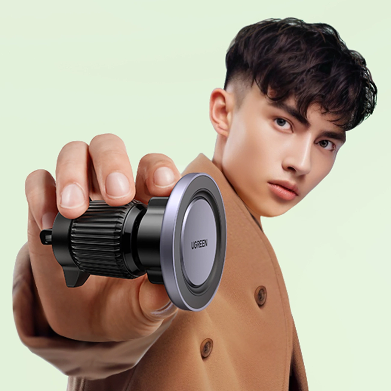 Ένας άντρας που κρατά στο χέρι του μια μαγνητική θήκη Ugreen LP428