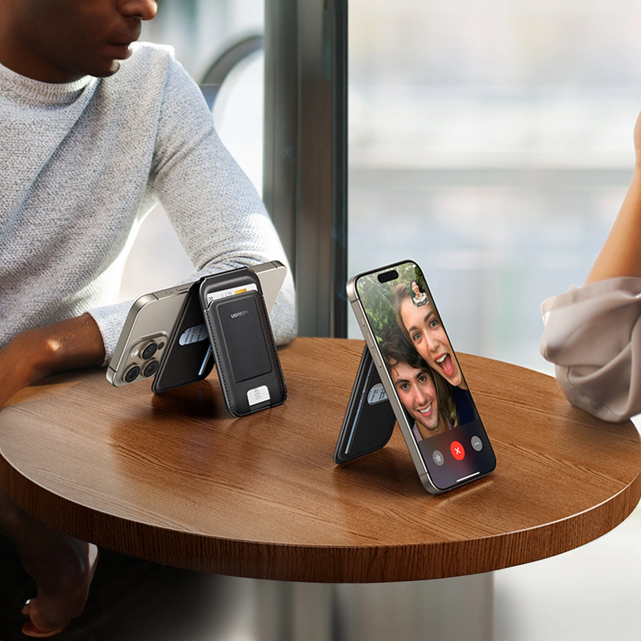 Δύο άτομα μιλούν στο τηλέφωνο ακουμπώντας στο τραπέζι χάρη στο Ugreen Magnetic Wallet 45165