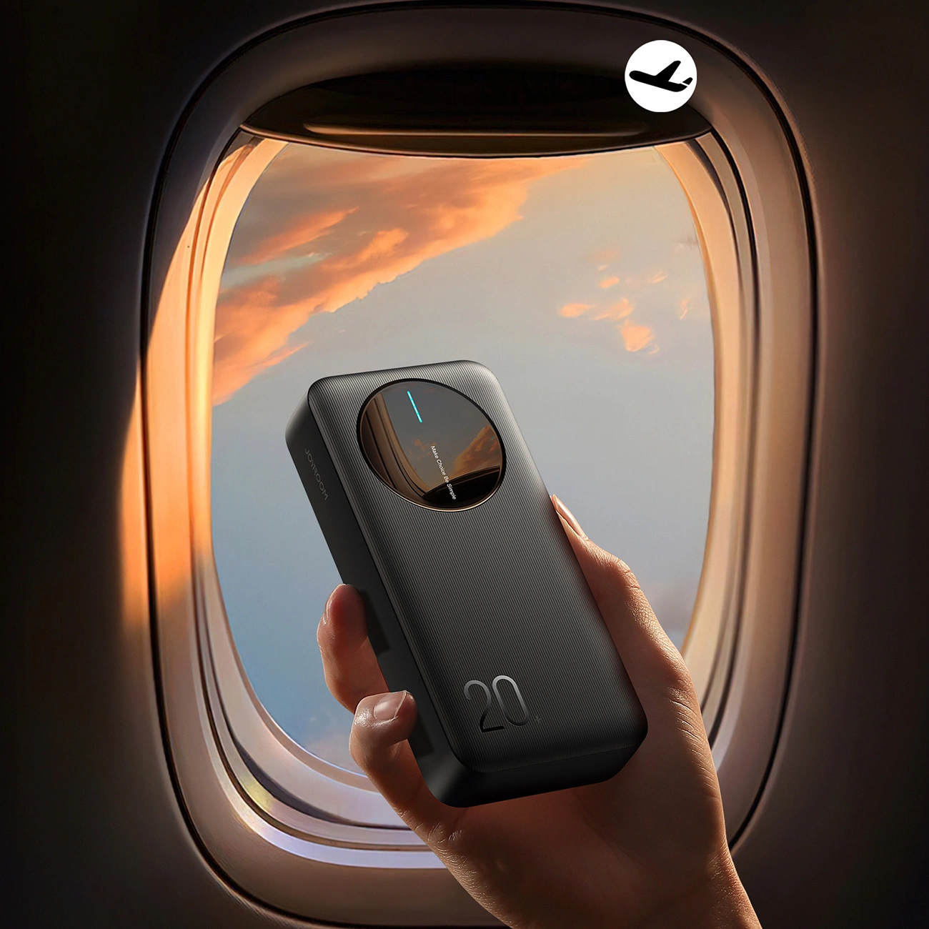 Μια γυναίκα κρατά ένα Joyroom JR-PBF14 Powerbank κοντά σε ένα παράθυρο αεροπλάνου