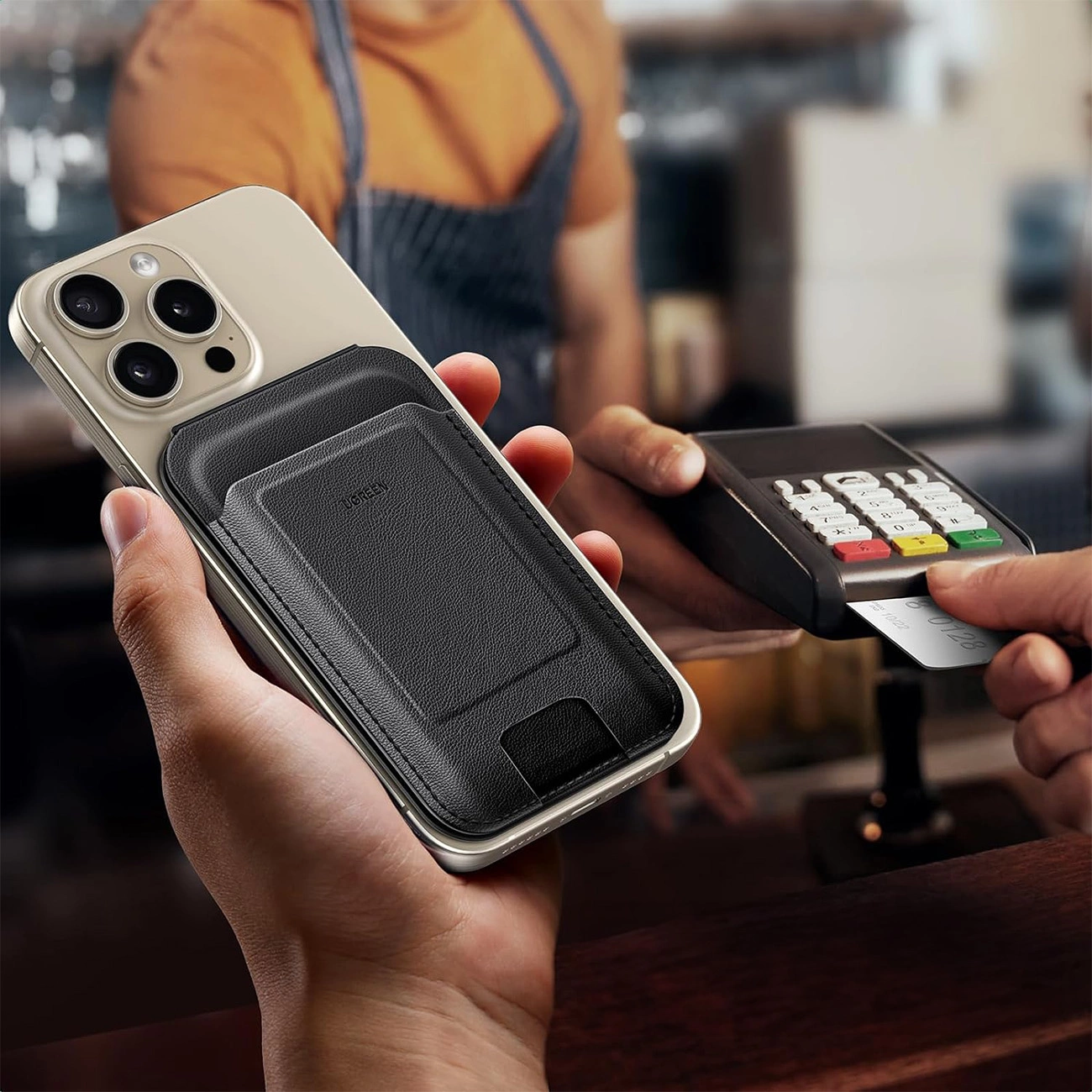 Το άτομο κρατά ένα τηλέφωνο στο χέρι του στο οποίο είναι συνδεδεμένο το Ugreen Magnetic Wallet 45165