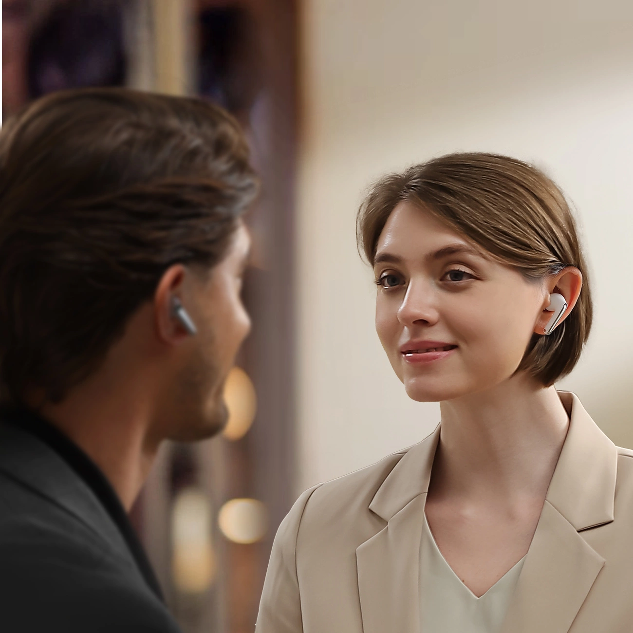 Μια γυναίκα μιλάει σε έναν άνδρα που φοράει ασύρματα ακουστικά στο αυτί Joyroom Funpods JR-FN1